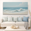 Beach-themed wall art above a white sofa with matching cushions in a living room setting.