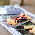 Platter of cheese and fruit on a table with a blurred background