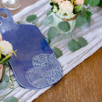 Blue cutting board with floral design on a wooden table