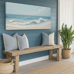 Nautical-themed room with a wooden bench, pillows, and a beach painting on a blue wall.