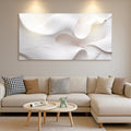 Modern living room with a beige sectional sofa, abstract wall art, and a small round coffee table.
