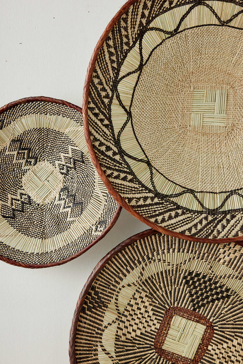Three woven baskets with geometric patterns on a white background