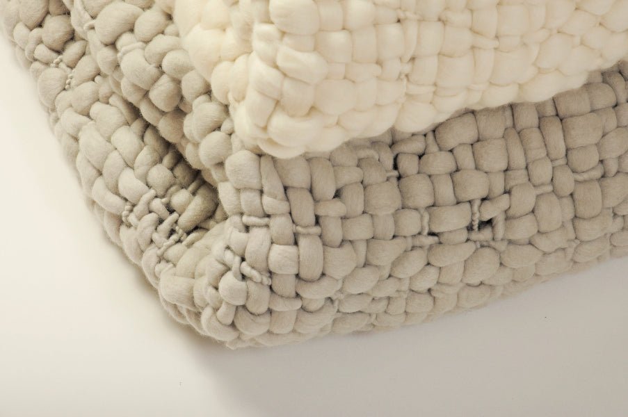 Stack of woven textured fabric in white and light gray on a light background