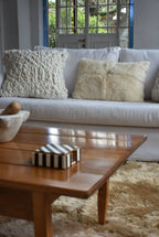 Living room with a white sofa, wooden coffee table, and decorative pillows. 