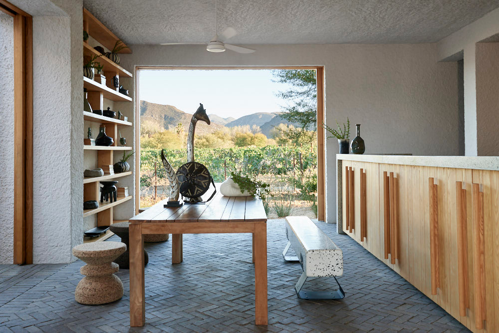 Modern interior with a wooden dining table, chairs, and shelves.