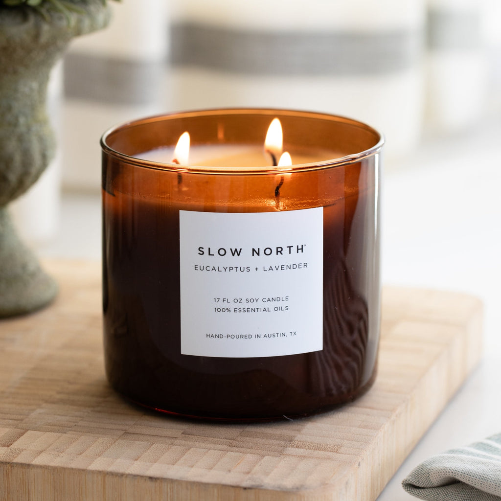 Candle with 'Slow North' label on a wooden surface