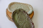 Two ceramic dishes with textured surfaces on a white background