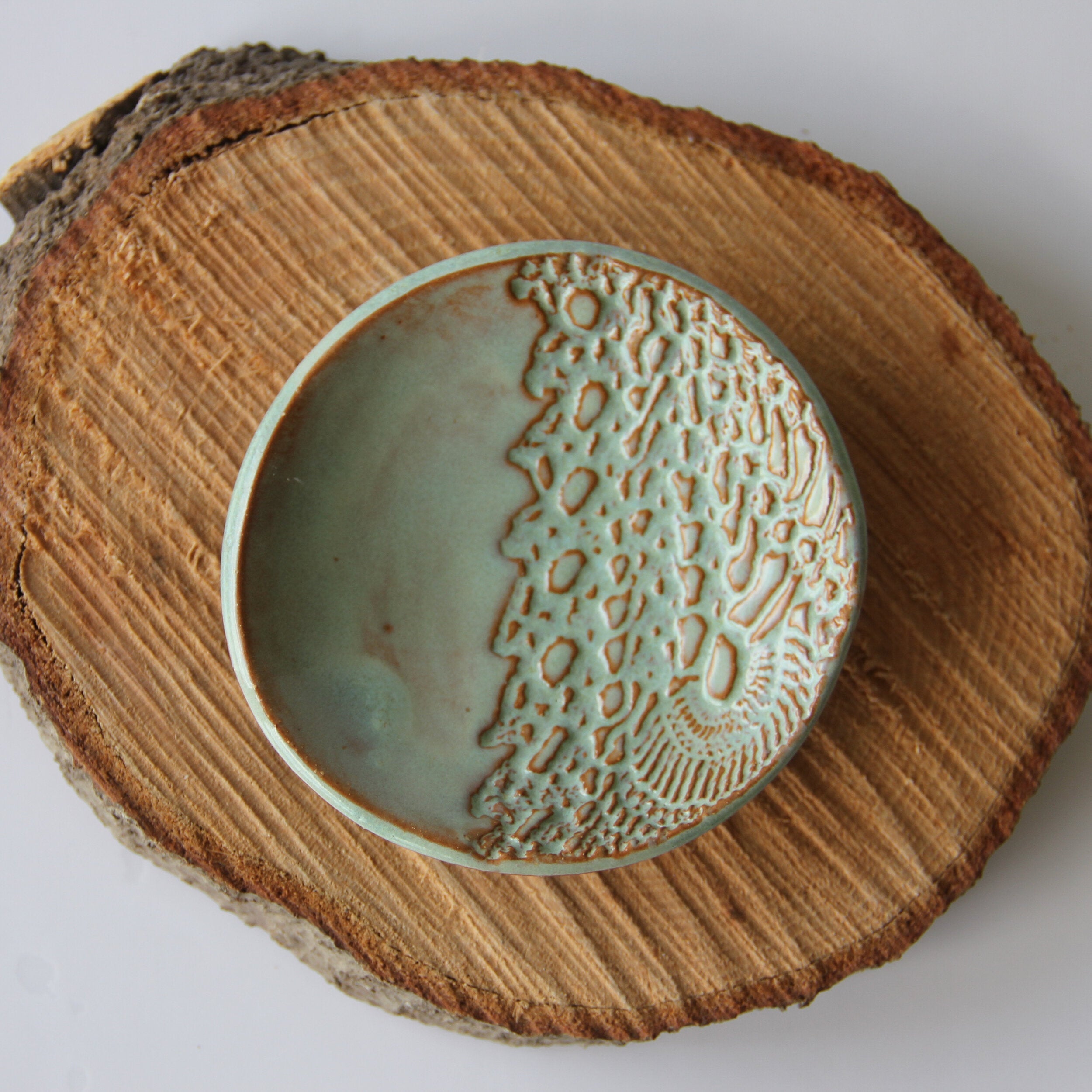 Ceramic ring dish with textured design on a wooden surface
