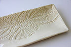Rectangular ceramic platter with textured surface on a white background