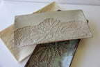 Beige ceramic platter with lace detailing on a white surface