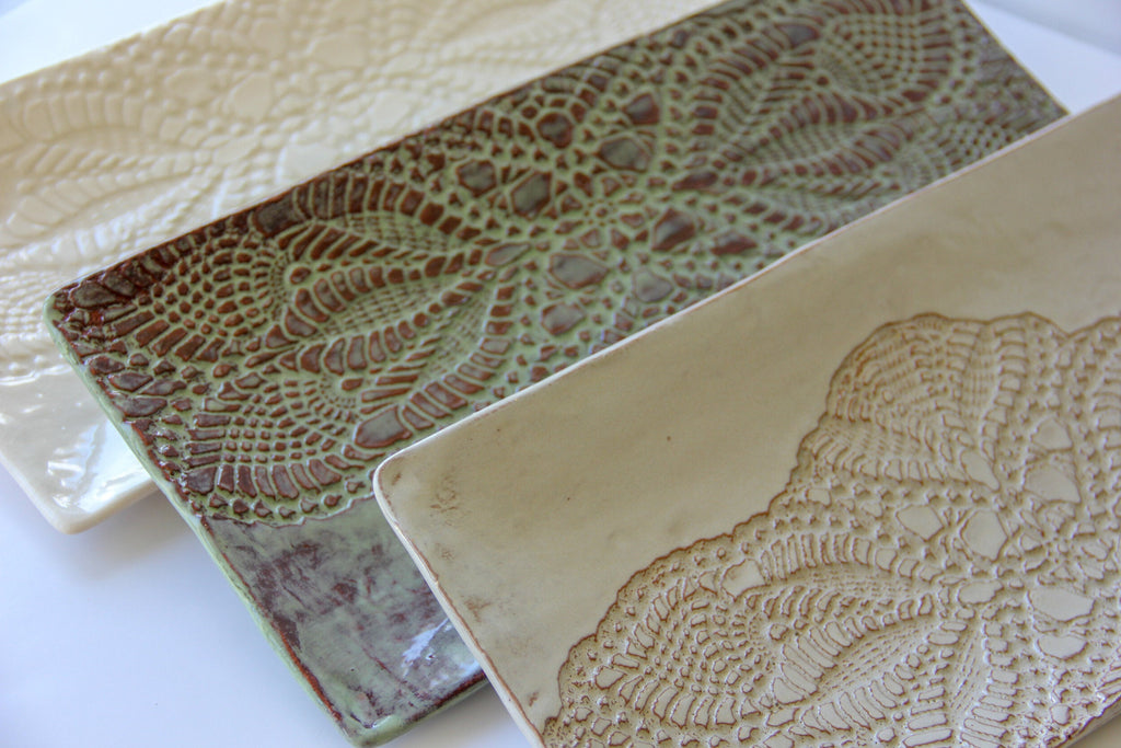 Two ceramic platters with textured patterns on a white surface