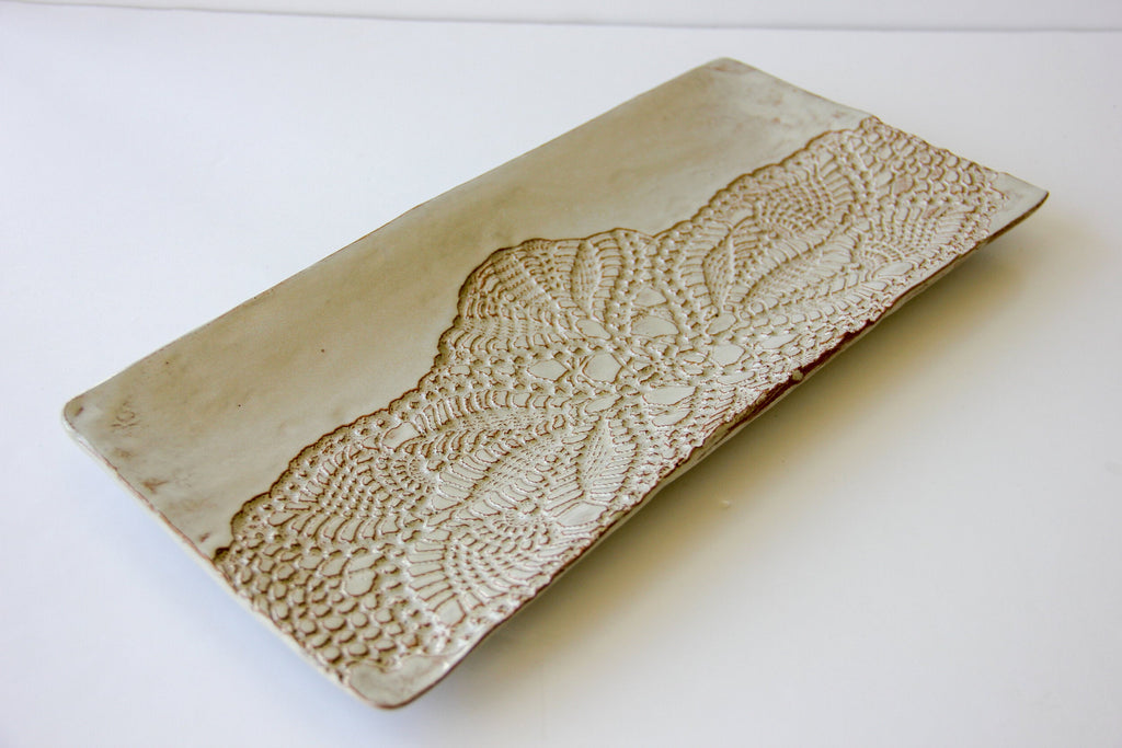 Decorative ceramic platter with textured pattern on a white background