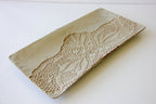 Decorative ceramic platter with textured pattern on a white background