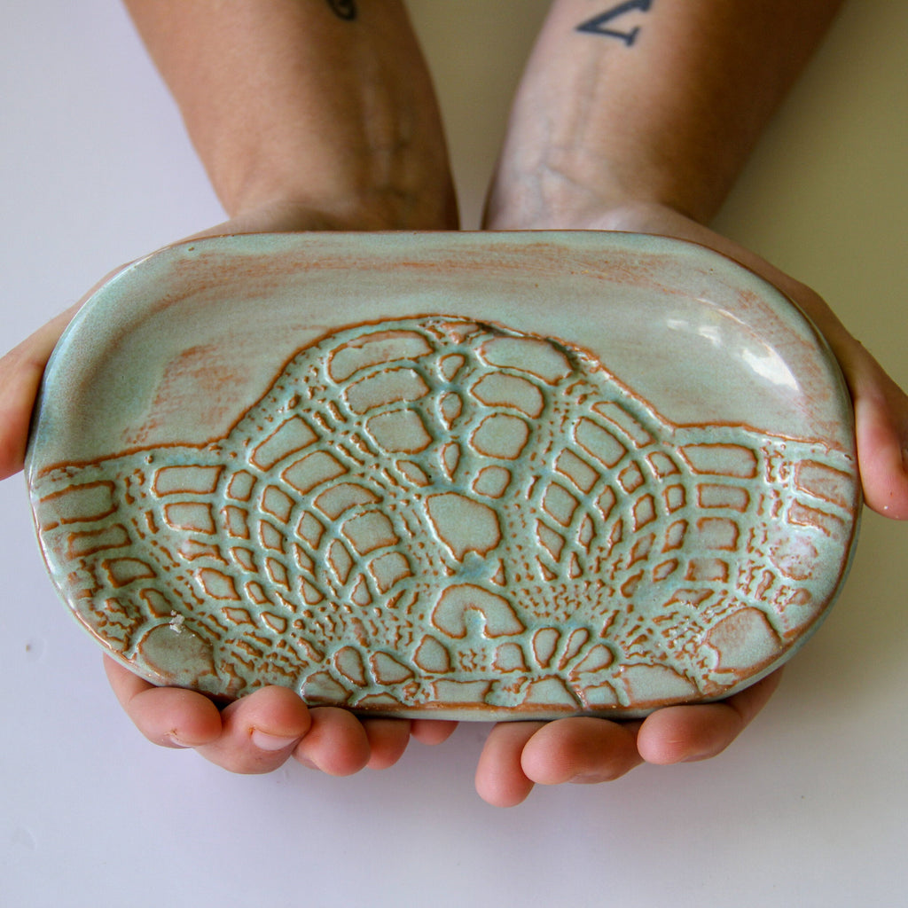 Person holding a ceramic dish with textured design