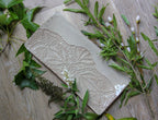 Decorative platter with intricate patterns on a wooden surface with greenery
