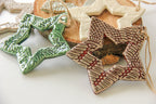 Star-shaped ceramic ornaments in various colors on a white surface