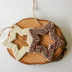 Decorative star-shaped ornaments on a wooden slice with a white background