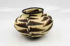 Handcrafted woven basket with geometric pattern on a white background