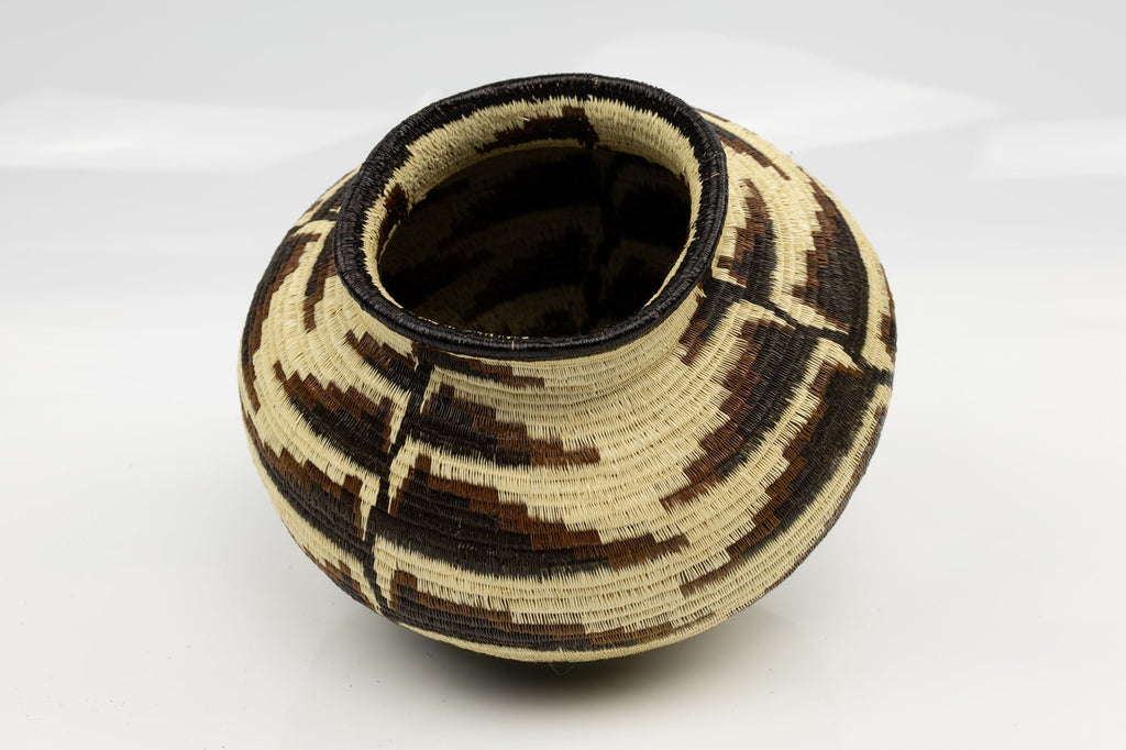 Woven basket with geometric pattern on a white background