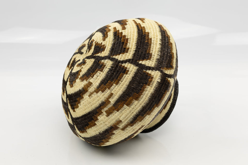 Woven basket with black and beige pattern on a white background