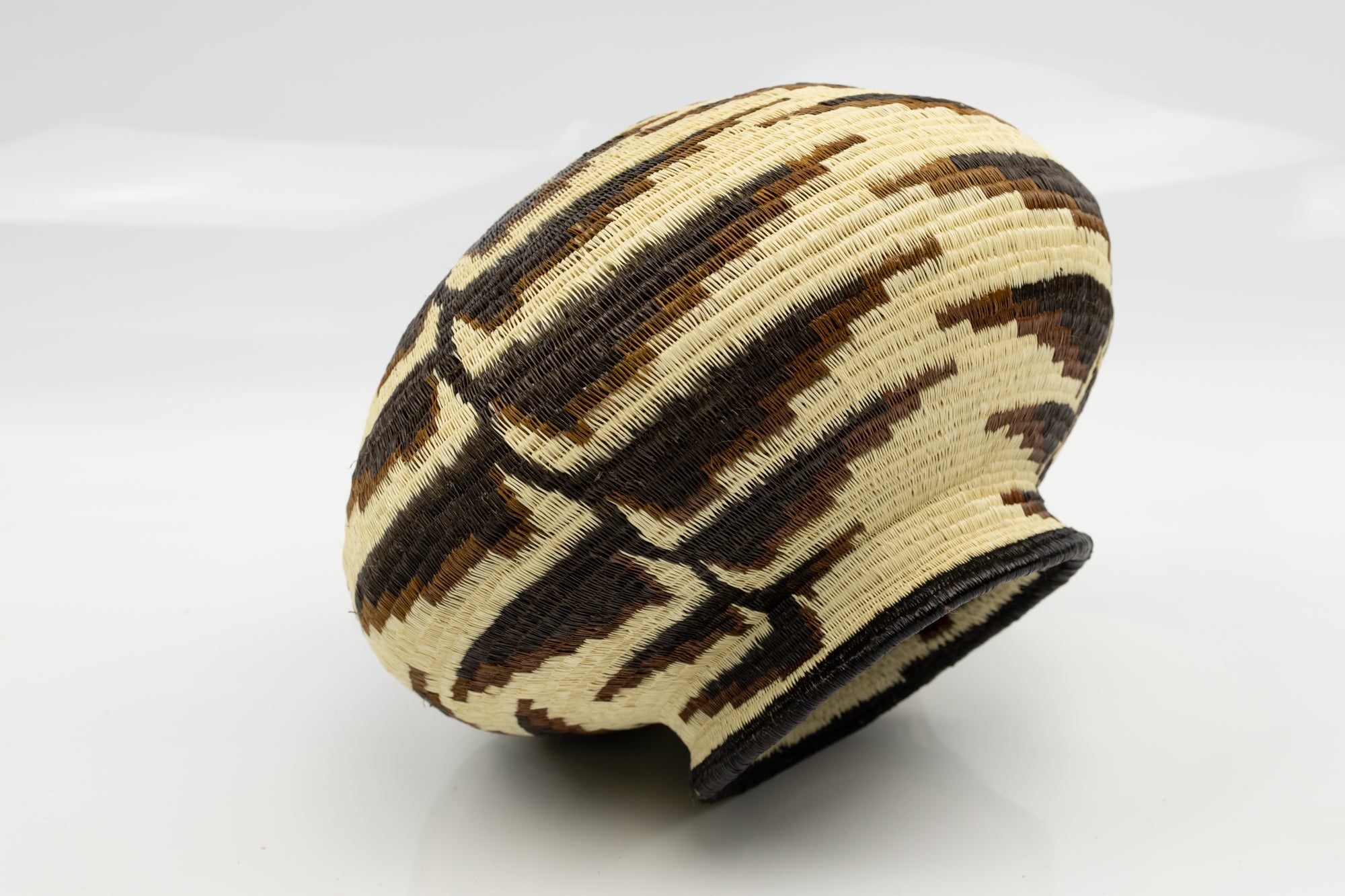 Woven basket with geometric pattern on a white background