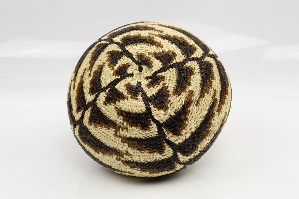 Woven basket with concentric circle pattern on a white background