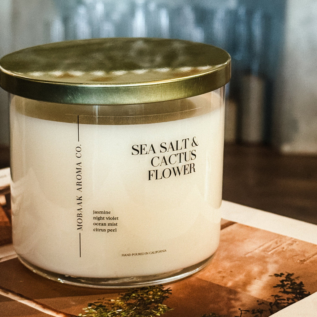 Candle with 'Sea Salt & Cactus Flower' fragrance on a wooden surface