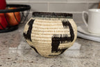 Woven basket with black and white pattern on a kitchen counter