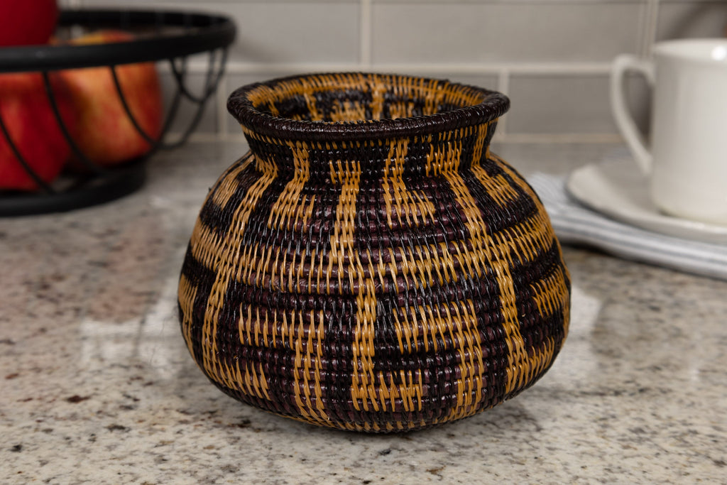 Woven basket with black and brown pattern on a kitchen counter