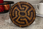 Woven basket bottom with black and brown pattern on a kitchen counter