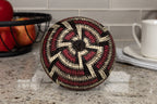 Decorative woven basket on a kitchen counter with apples and a mug in the background