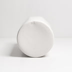 White ceramic vase on its side on a light gray background