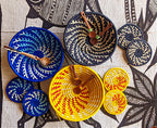 Woven baskets with wooden spoons on a patterned fabric background