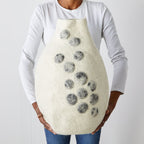 Person holding a textured vase with pebble print designs against a larger plain background