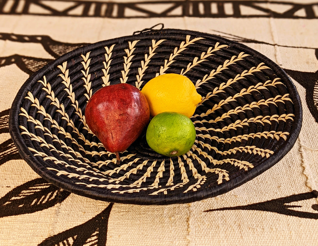 Decorative woven plate with fruits on a patterned fabric background