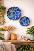 Decorative blue spiral plates on a wall with a wooden console table and home decor items.