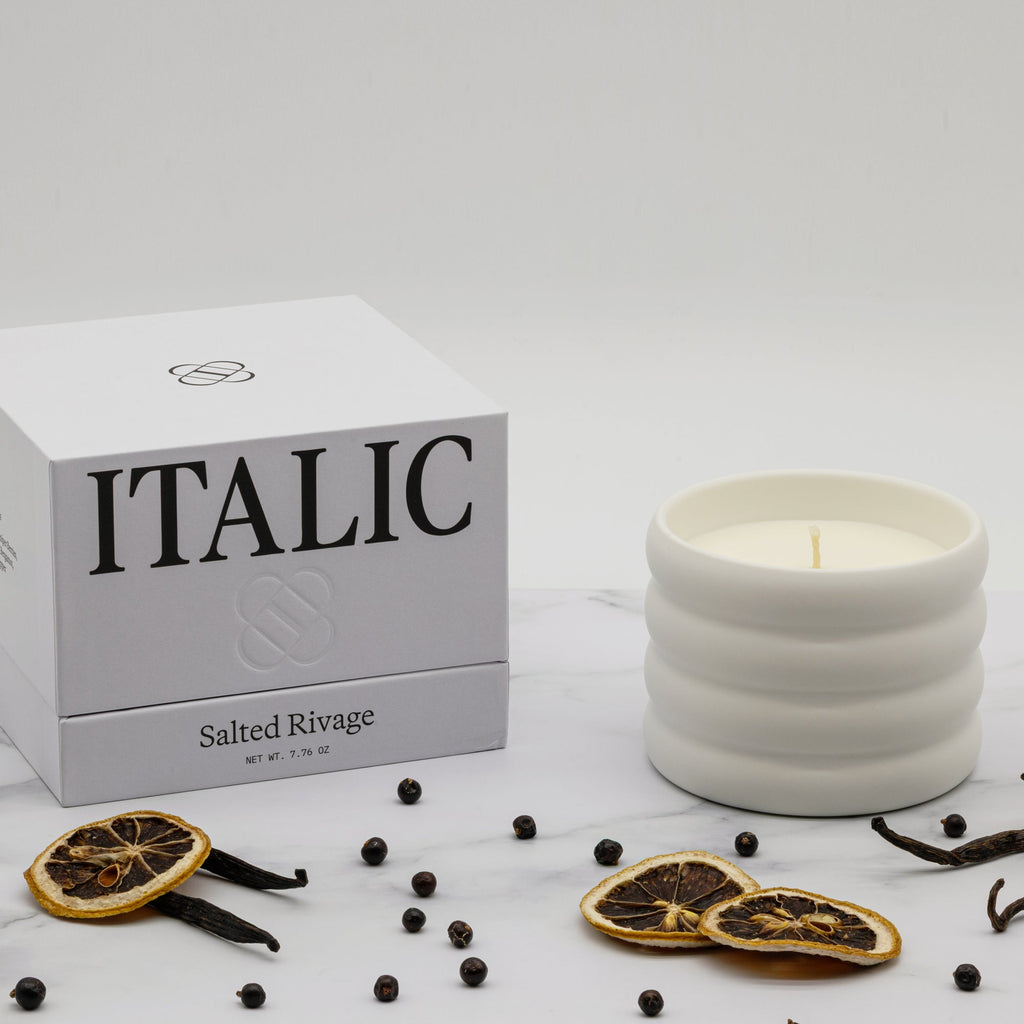White candle with decorative elements and 'Italic' packaging on a white background