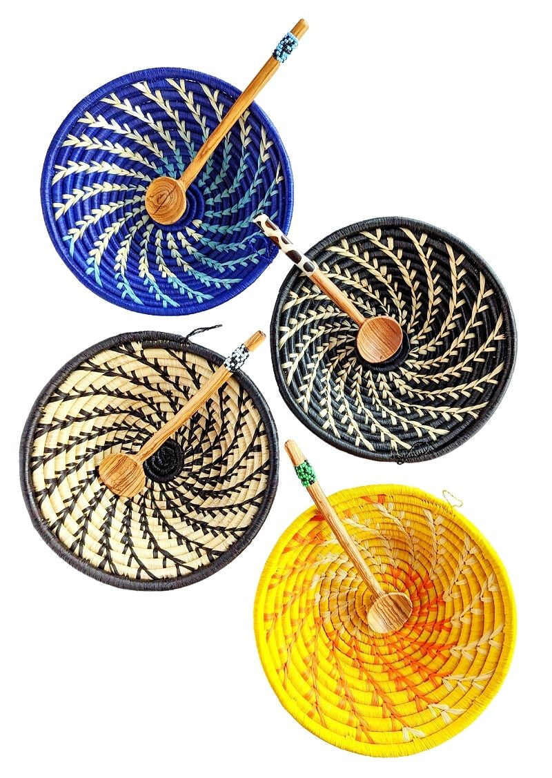 Set of four woven coasters with wooden spoons in blue, black, and yellow on a white background.