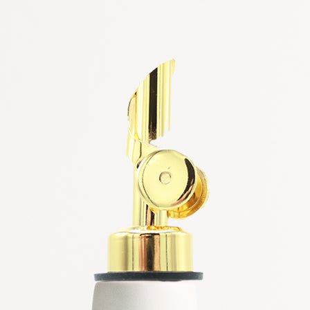 Gold-colored oil dispenser nozzle on a white background