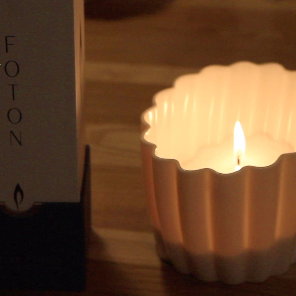 Candle in a decorative holder with a blurred box in the background