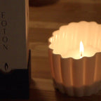 Candle in a decorative holder with a blurred box in the background