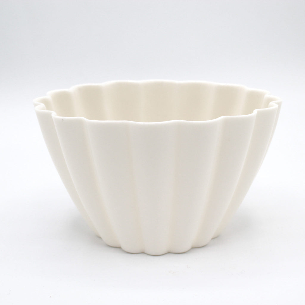 White ceramic bowl with a textured surface on a white background