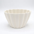 White ceramic bowl with a textured surface on a white background