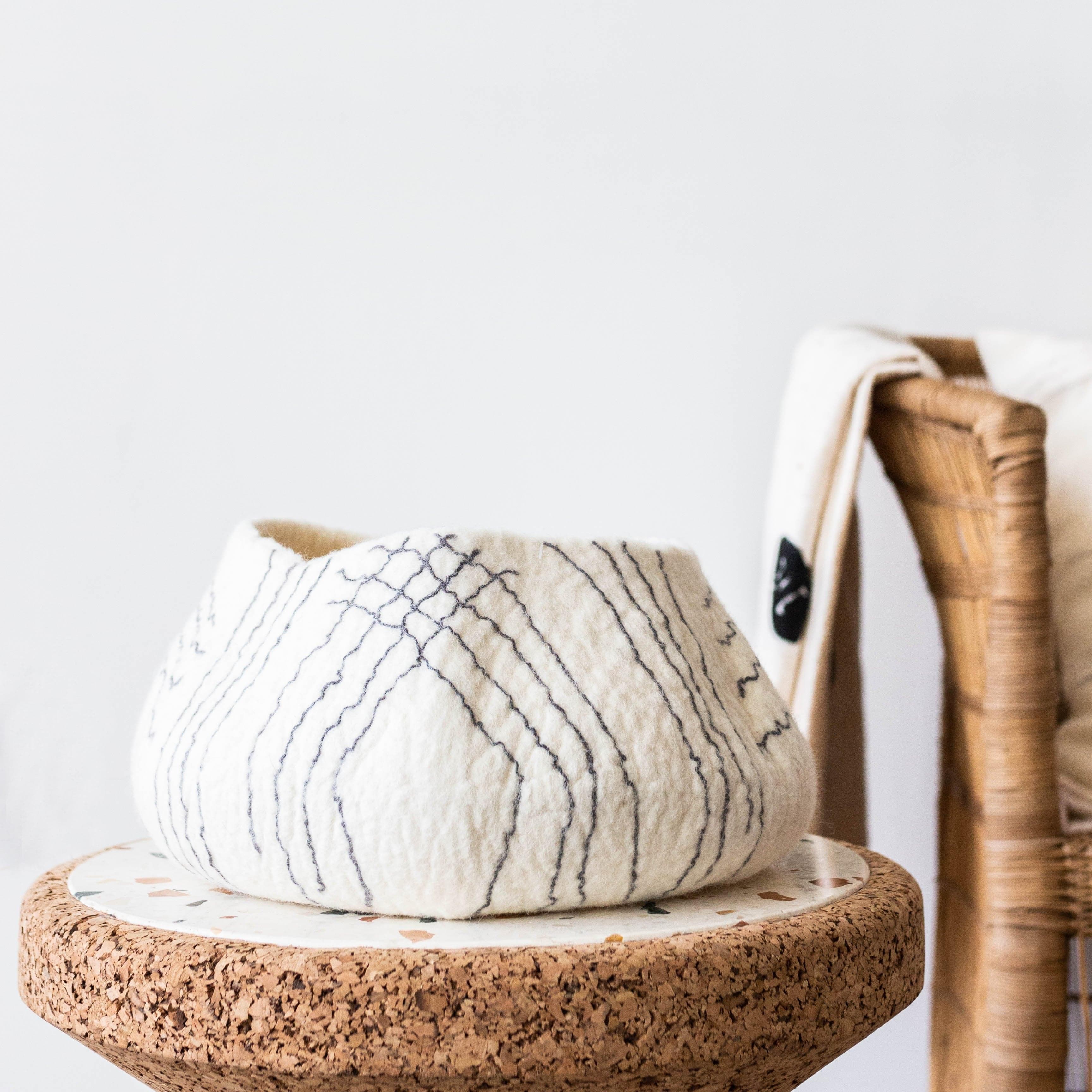 Textured white bowl with pattern on a cork base with a blurred background