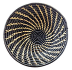 Round woven coaster with black and gold pattern on a white background