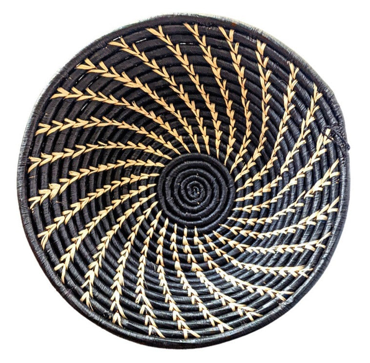 Round woven coaster with black and gold pattern on a white background