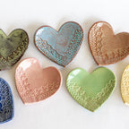 Set of ceramic heart-shaped dishes with textured surfaces on a white background