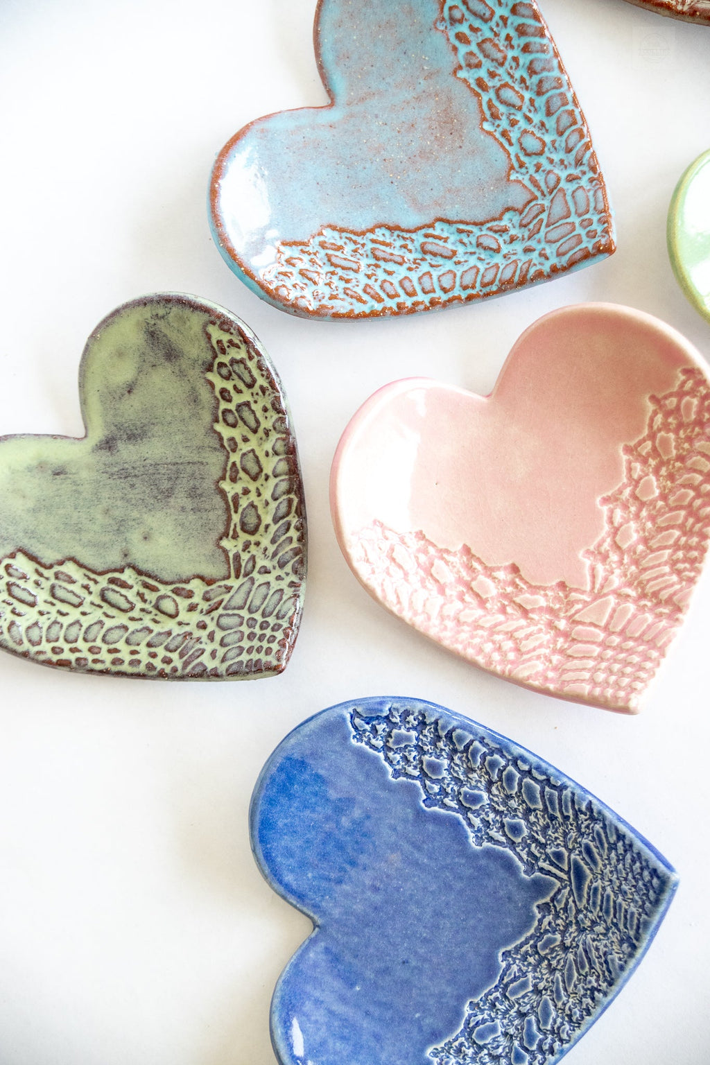 Heart-shaped ceramic dishes in various colors on a white background