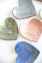 Heart-shaped ceramic dishes in various colors on a white background