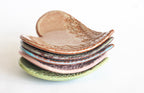 Stack of ceramic leaf-shaped dishes on a white background